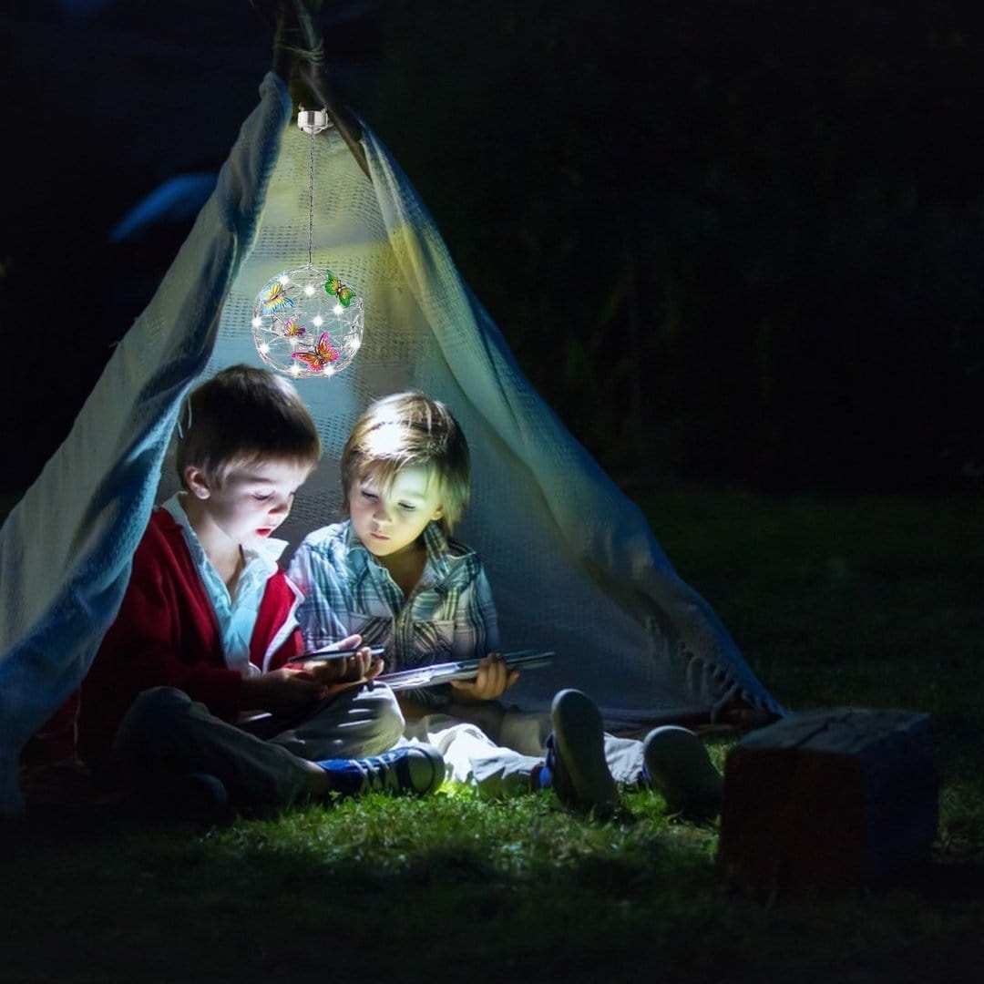 Hengende solcellelampe formet som en kule med sommerfugler
